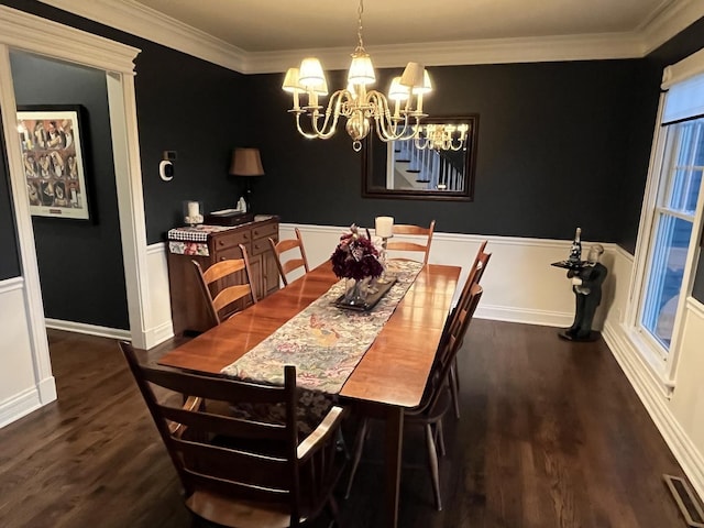 dining room featuring dark hardwood / wood-style flooring, ornamental molding, and an inviting chandelier