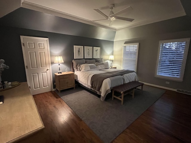 bedroom featuring a tray ceiling, ceiling fan, dark hardwood / wood-style flooring, and ornamental molding