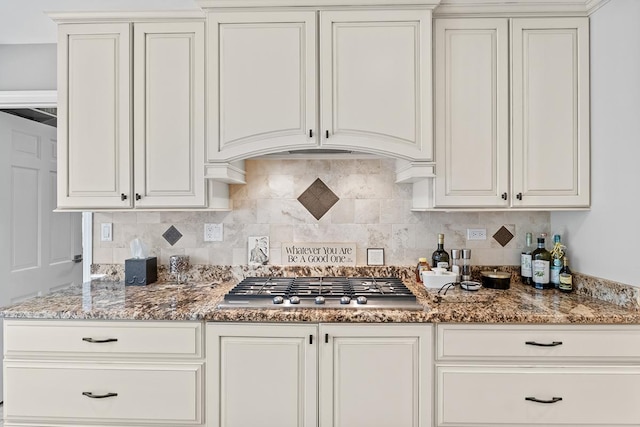kitchen featuring stone counters, white cabinetry, stainless steel gas cooktop, and decorative backsplash
