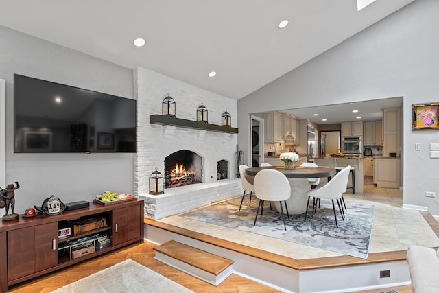 dining area with high vaulted ceiling, a fireplace, light tile patterned flooring, and recessed lighting