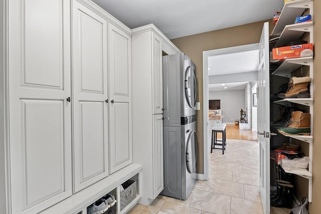interior space with baseboards and stacked washer / drying machine