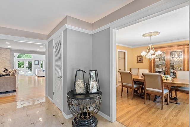 dining space with crown molding, french doors, a notable chandelier, and wood finished floors