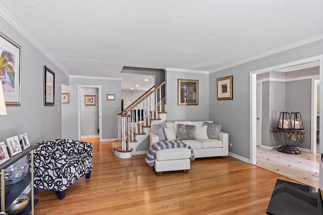 living area featuring light wood-style floors, ornamental molding, stairway, and baseboards