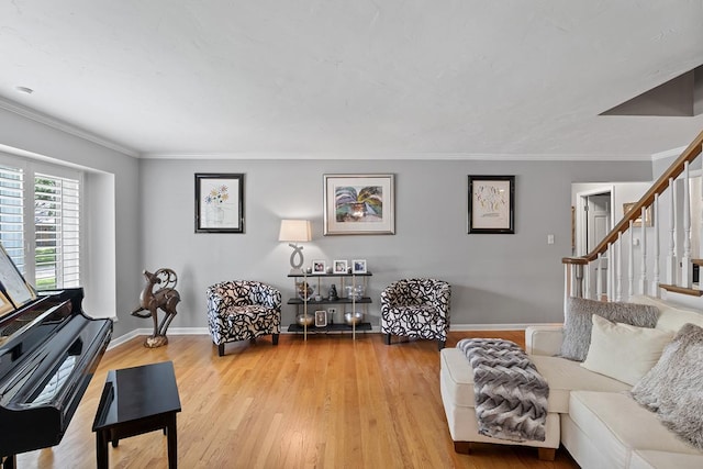 living area featuring light wood-type flooring, stairway, and crown molding