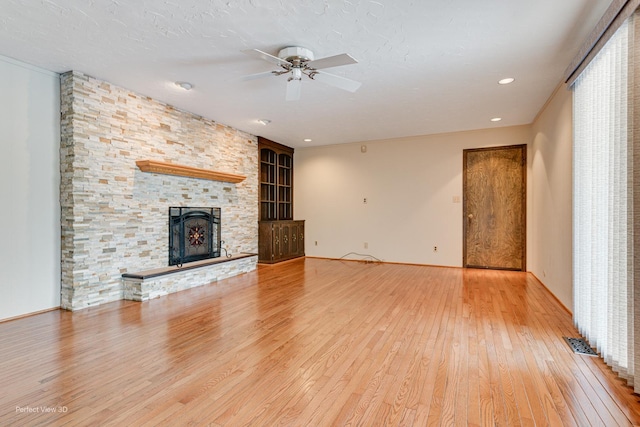 unfurnished living room with ceiling fan, wood-type flooring, and a fireplace