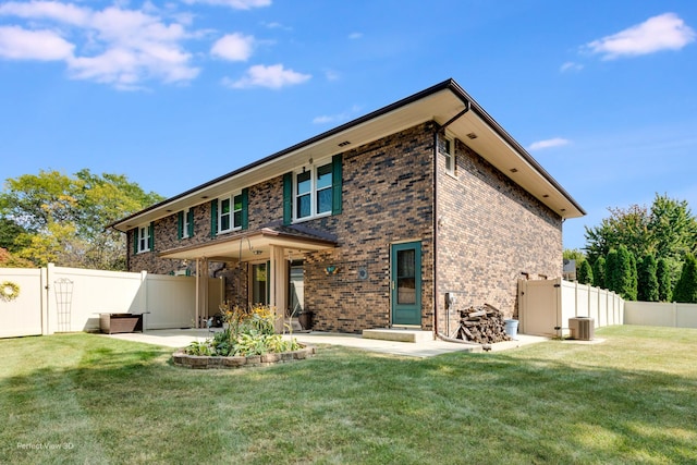 rear view of house with a patio area, central AC, and a yard