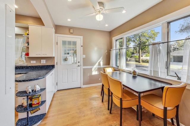 dining space with ceiling fan and light hardwood / wood-style flooring