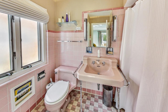 bathroom featuring toilet and tile walls