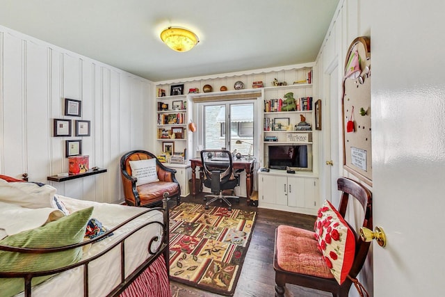 sitting room featuring dark wood-type flooring and built in features