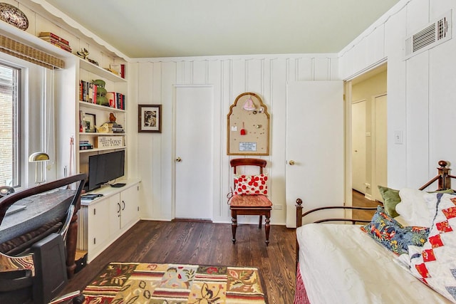 bedroom featuring built in desk and dark hardwood / wood-style flooring