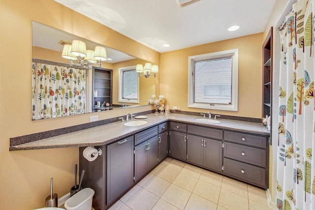 bathroom with vanity, an inviting chandelier, and tile patterned flooring