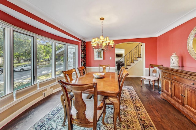 dining room featuring crown molding, dark hardwood / wood-style floors, and a chandelier