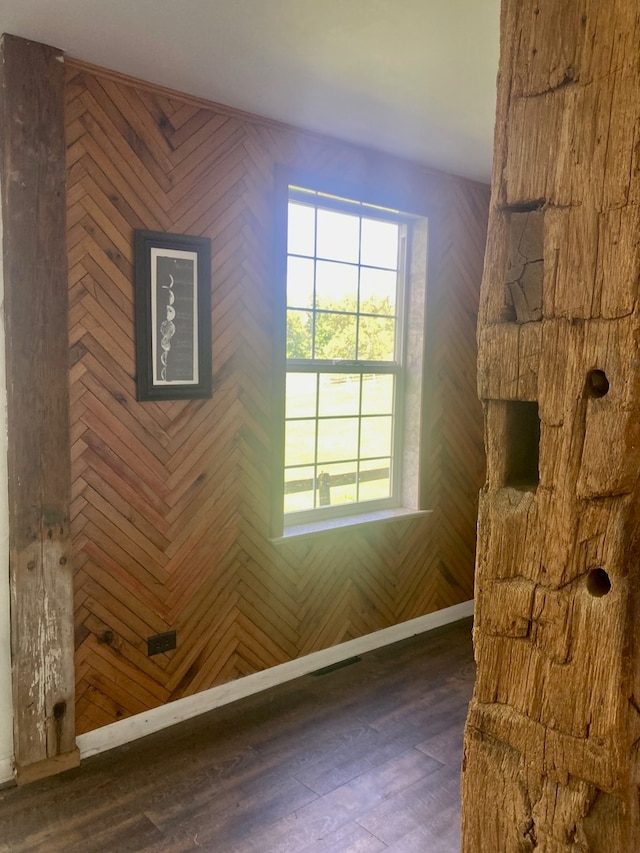 interior space featuring dark hardwood / wood-style flooring and wood walls