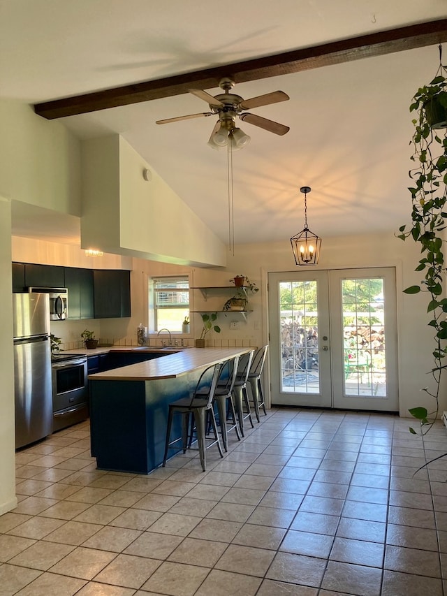 kitchen with stainless steel appliances, light tile patterned floors, a kitchen breakfast bar, high vaulted ceiling, and beam ceiling