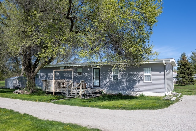 ranch-style house featuring a front yard and a deck