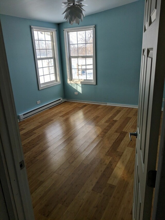 empty room featuring ceiling fan, dark hardwood / wood-style floors, and a baseboard radiator