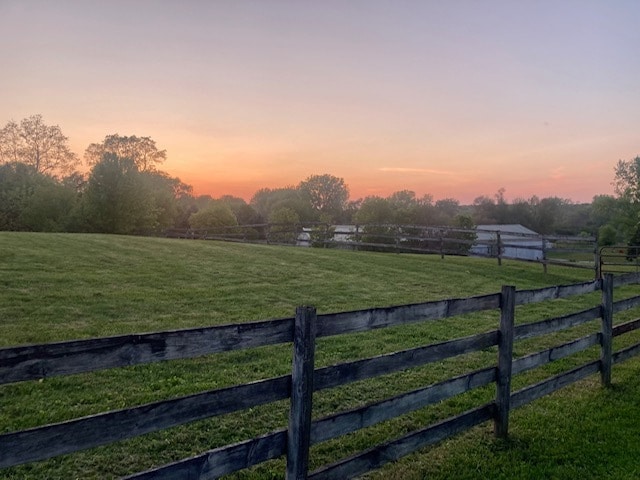 yard at dusk with a rural view