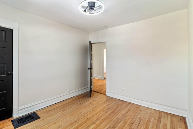 spare room with light wood-type flooring, baseboards, and visible vents