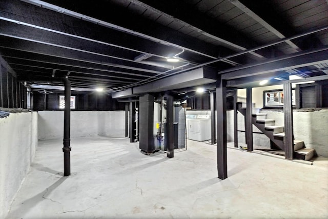 unfinished basement with stairway and independent washer and dryer