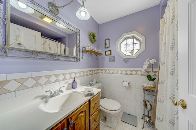 bathroom featuring tile patterned floors, toilet, washer / dryer, vanity, and tile walls