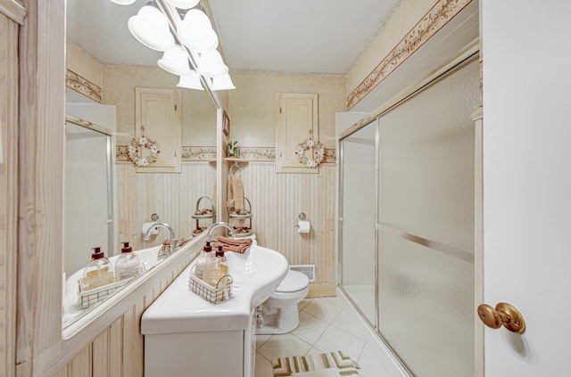 bathroom featuring a shower with door, toilet, and tile patterned flooring