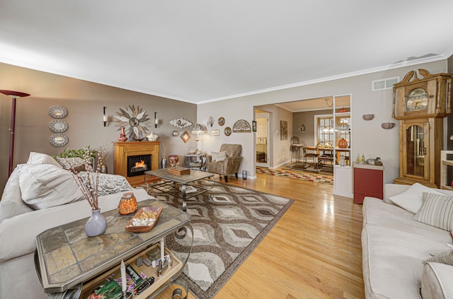 living room featuring hardwood / wood-style floors, a notable chandelier, and crown molding