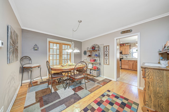 dining space featuring light hardwood / wood-style flooring, french doors, and crown molding