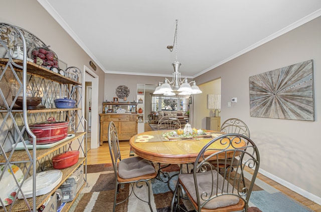 dining room featuring ornamental molding, hardwood / wood-style floors, and a notable chandelier