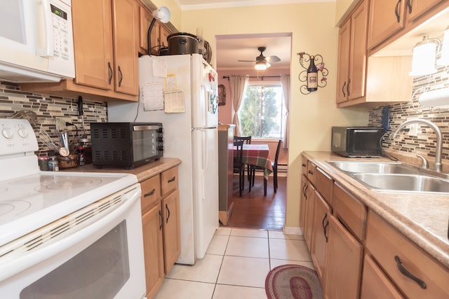 kitchen with light tile patterned floors, backsplash, ornamental molding, sink, and white appliances