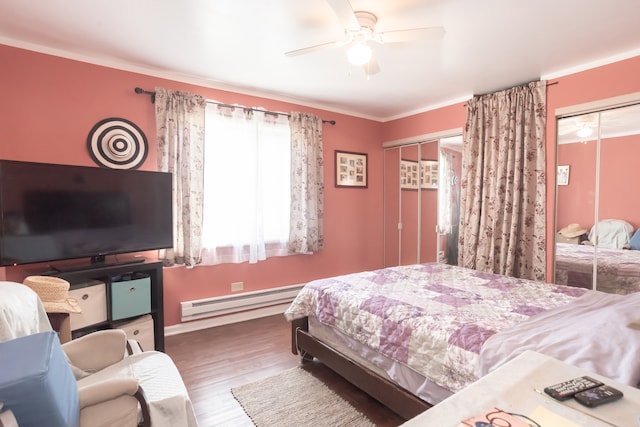 bedroom with a baseboard heating unit, ceiling fan, hardwood / wood-style flooring, crown molding, and a closet