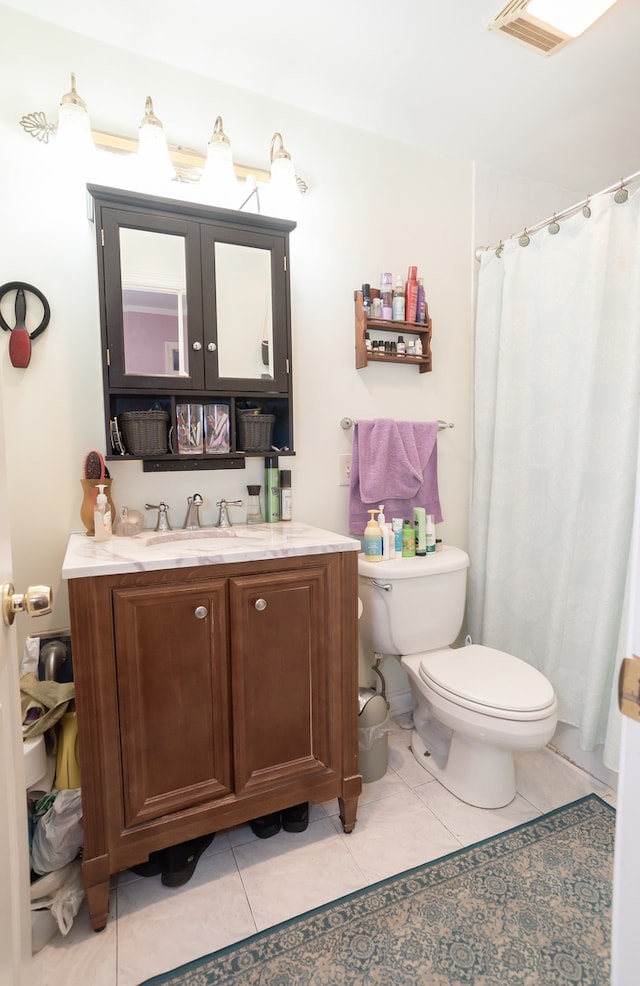 bathroom with vanity, toilet, and tile patterned flooring