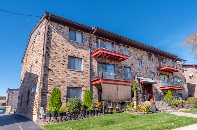 exterior space featuring a balcony and a front lawn