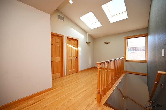 hallway featuring vaulted ceiling and light wood-type flooring