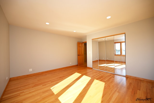 unfurnished bedroom featuring a closet and light hardwood / wood-style flooring