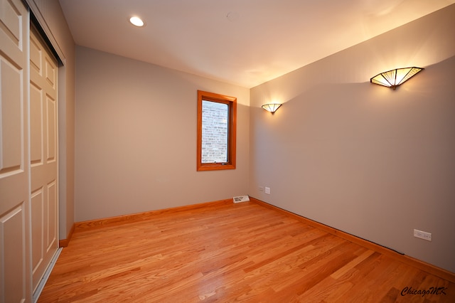 unfurnished bedroom with a closet and light hardwood / wood-style floors