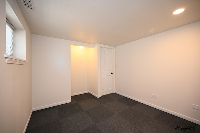 unfurnished room with dark carpet