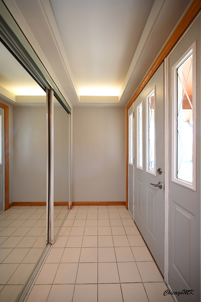 tiled entrance foyer with a raised ceiling