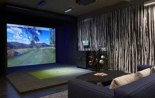 game room with a mountain view, wood-type flooring, and golf simulator