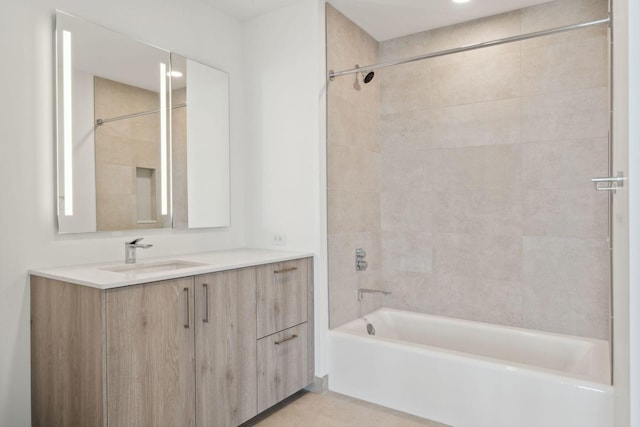 bathroom with tile patterned floors, vanity, and tiled shower / bath