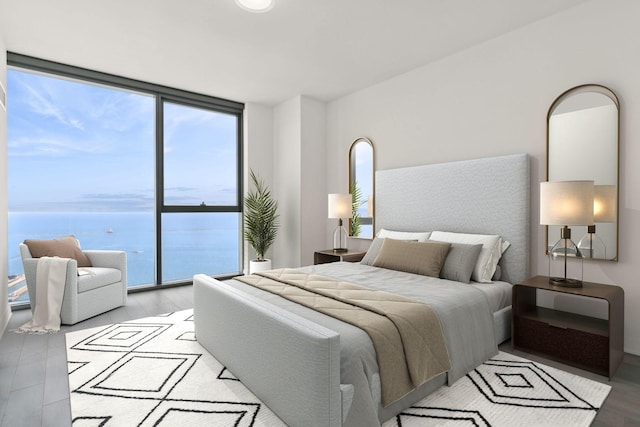 bedroom featuring access to exterior, light hardwood / wood-style flooring, a water view, and a wall of windows