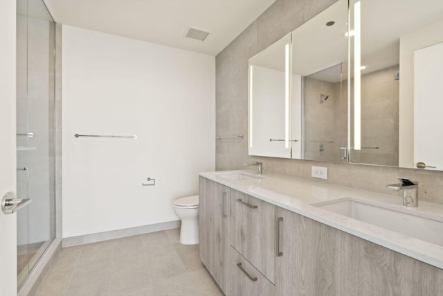 bathroom featuring tile patterned floors, vanity, toilet, and an enclosed shower