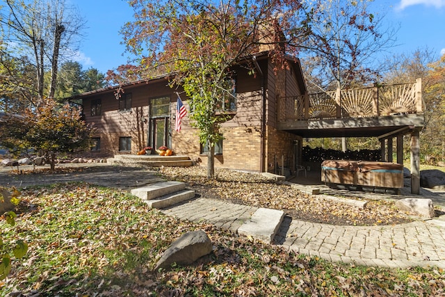 exterior space with a hot tub, a patio area, and a wooden deck