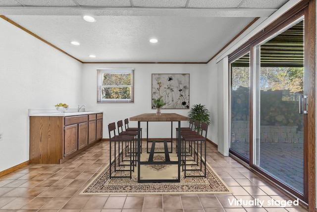 dining space featuring ornamental molding, sink, light tile patterned floors, and a wealth of natural light