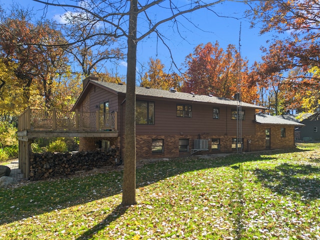 back of property with cooling unit, a deck, and a lawn