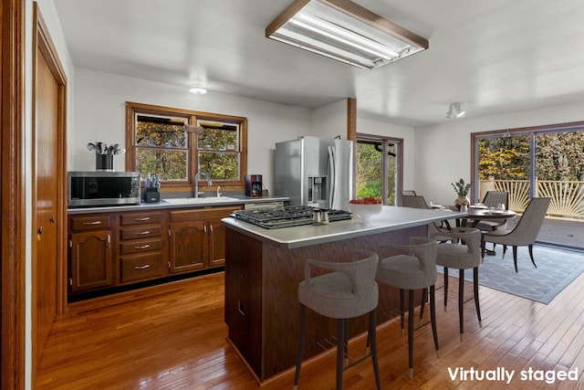 kitchen featuring a kitchen island, sink, appliances with stainless steel finishes, and light hardwood / wood-style floors