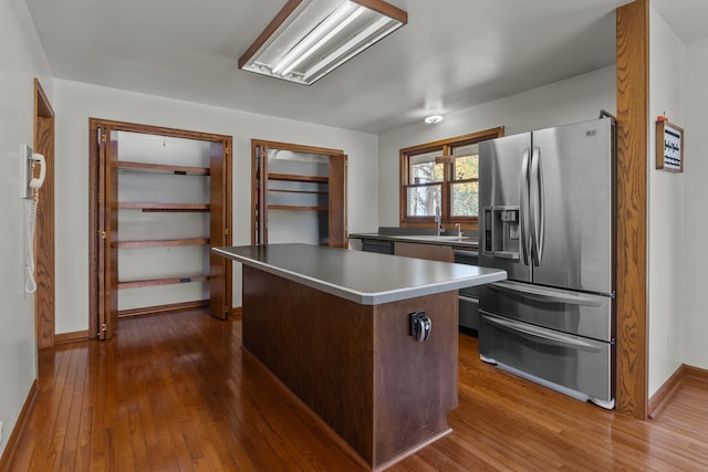 kitchen featuring sink, a kitchen island, stainless steel refrigerator with ice dispenser, and wood-type flooring