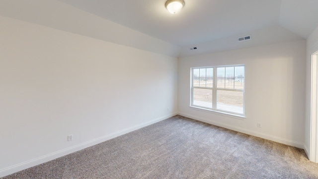 empty room with lofted ceiling and carpet flooring