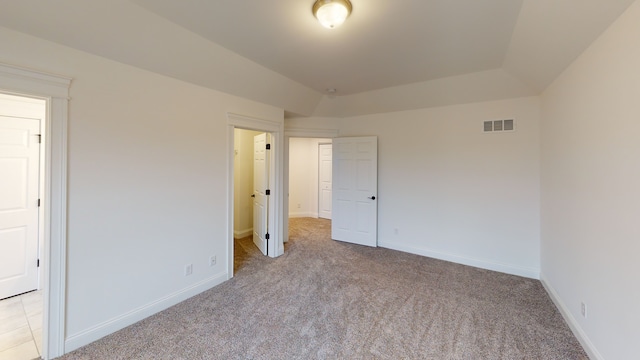 unfurnished bedroom featuring light carpet and vaulted ceiling