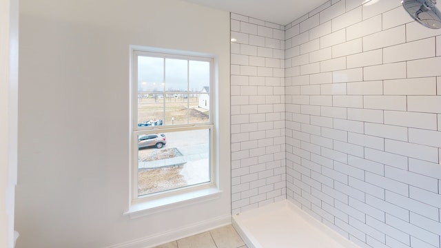 bathroom featuring tile patterned flooring and tiled shower