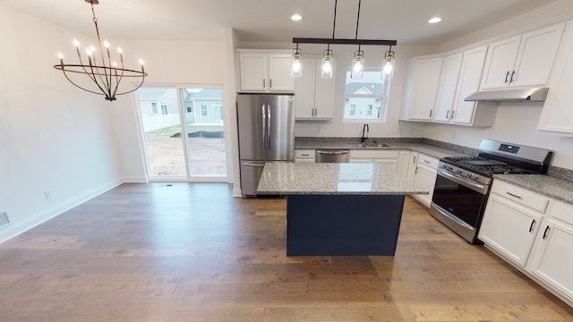 kitchen featuring hardwood / wood-style floors, a kitchen island, white cabinetry, and stainless steel appliances